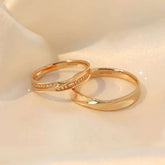 Pair of crossover yellow-gold rings (diamond + plain) sparkling on satin fabric